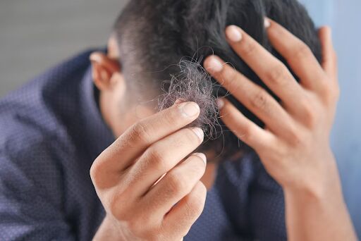 A Man Thinking he sees The First Symptoms Of Hair Loss